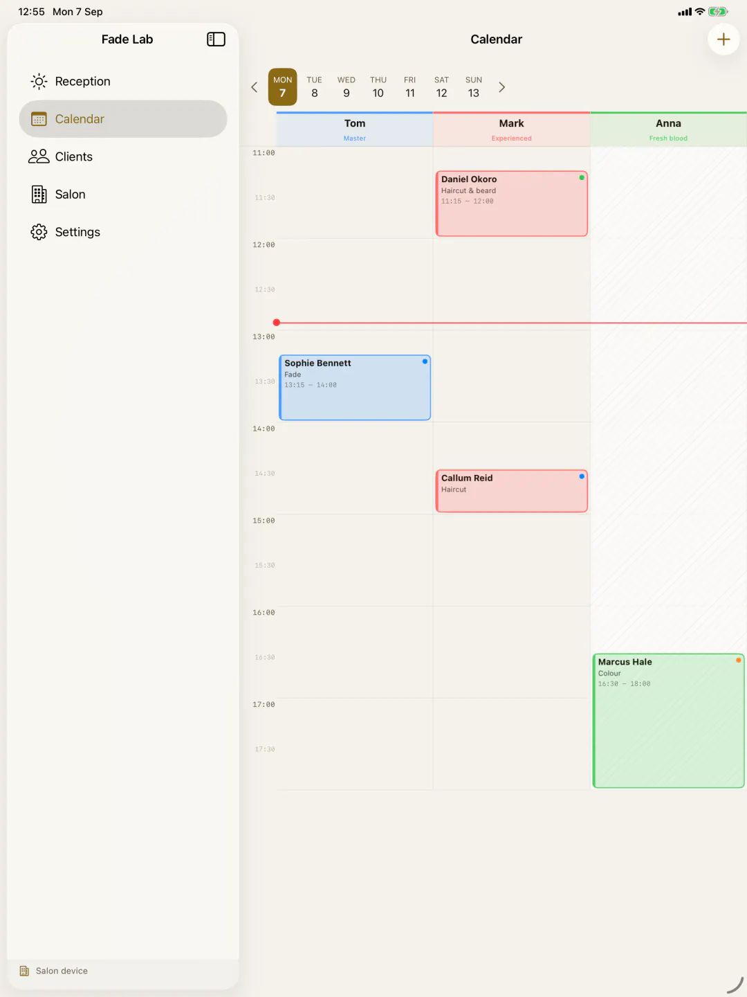 The team calendar on an iPad: a column per barber, a line at the current hour, greyed-out hours outside work.